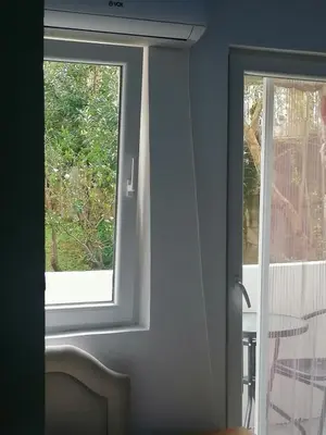 a room with a door with a window and a chair at Mini Candy central location Bečići in Becici