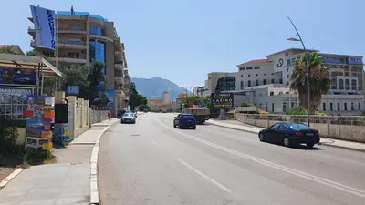 a city street with cars driving down the road at Mini Candy central location Bečići in Becici
