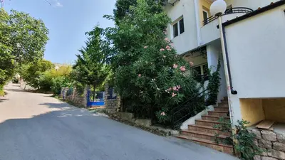 a building with a tree with pink flowers on it at Mini Candy central location Bečići in Becici