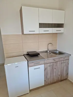 a kitchen with a white refrigerator and a sink at HM Apartmani in Bar
