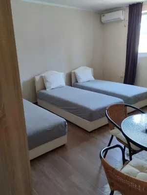 a room with two beds and a table and a table at HM Apartmani in Bar