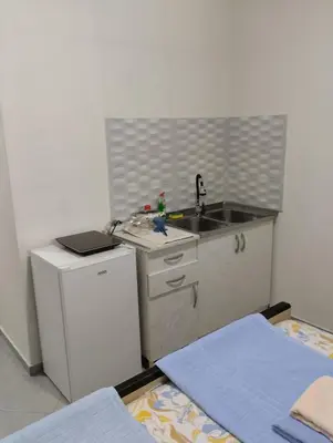 a small kitchen with a sink and a refrigerator at HM Apartmani in Bar