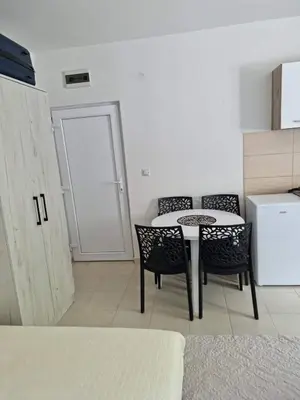a kitchen with a table and chairs in a room at HM Apartmani in Bar