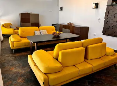 a living room with a yellow couch and a table at Beach Villa Žukovica in Radanovići
