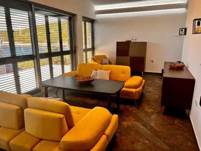 a living room with yellow couches and a table at Beach Villa Žukovica in Radanovići
