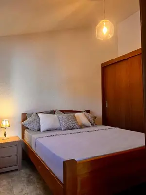 a bedroom with a large bed with a wooden headboard at Beach Villa Žukovica in Radanovići