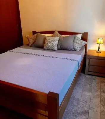 a bedroom with a large bed with pillows at Beach Villa Žukovica in Radanovići