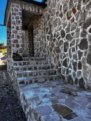 a stone building with stairs in front of it at Beach Villa Žukovica in Radanovići
