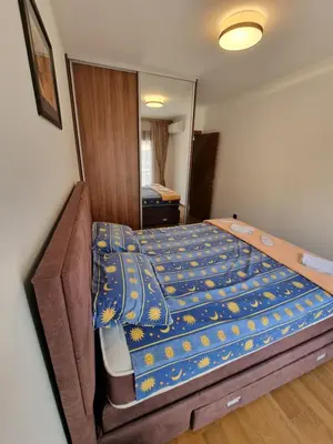 a bedroom with a bed with a blue comforter at Fantastic new centre apartment in Podgorica