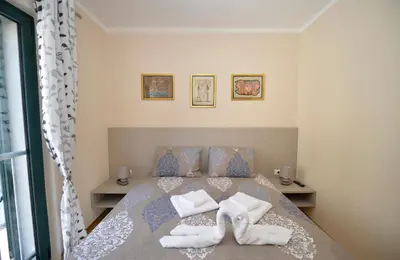 a bedroom with a bed with towels on it at Promenade,5 min Old Town in Kotor