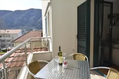 a table with a bottle of wine on a balcony at Promenade,5 min Old Town in Kotor
