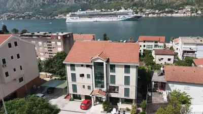 a cruise ship in the water next to buildings at Promenade,5 min Old Town in Kotor