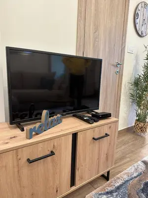 a flat screen tv sitting on top of a wooden entertainment center at Apartment Aki in Kotor