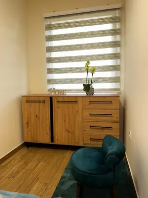 a room with a chair in front of a window at Apartment Aki in Kotor