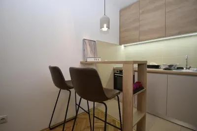 a kitchen with two chairs and a table in it at Studio apartment Art Zone in Podgorica