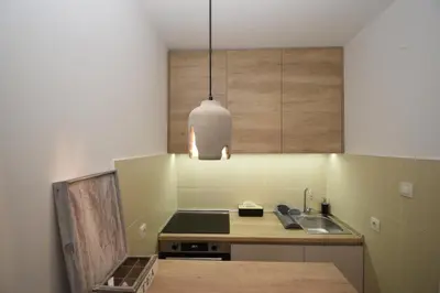 a kitchen with a sink and a pendant light at Studio apartment Art Zone in Podgorica