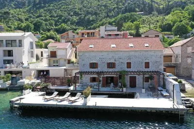 a large house on a dock in the water at Waterfront Villa in Muo in Kotor