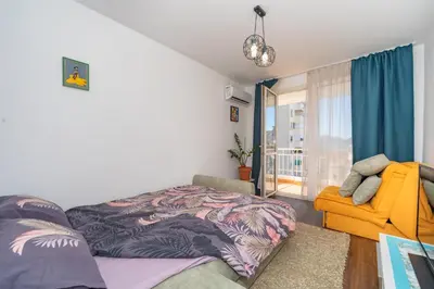 a bedroom with a bed and a yellow chair at Aloha Apartman in Bar