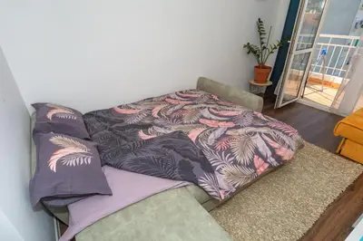 a couch with a blanket on top of it at Aloha Apartman in Bar