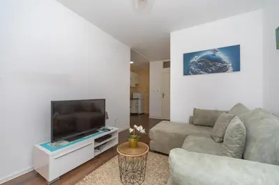 a living room with a couch and a flat screen tv at Aloha Apartman in Bar