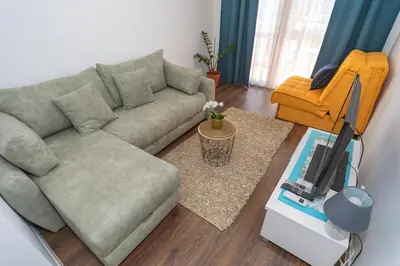 a living room with a couch and a tv at Aloha Apartman in Bar