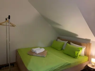 a bedroom with a green bed with green pillows at Apartman Vucinic in Cetinje