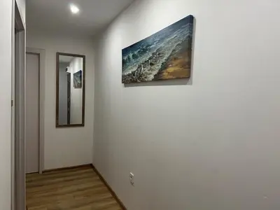 a hallway with two paintings on a white wall at Apartman Vucinic in Cetinje