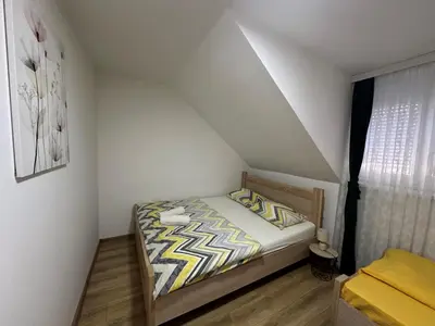 a small bedroom with a bed in a attic at Apartman Vucinic in Cetinje
