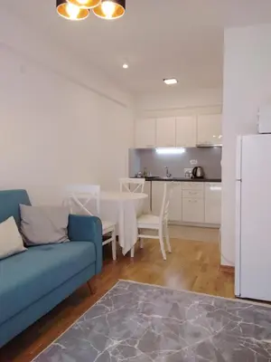 a living room with a table and a blue couch at Yeshill Homes in Budva