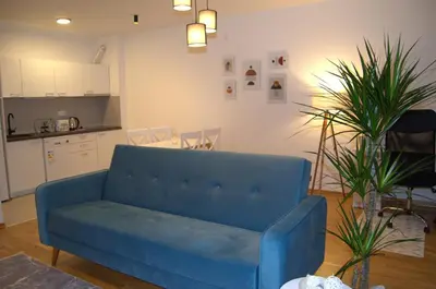 a blue couch in a living room with a kitchen at Yeshill Homes in Budva