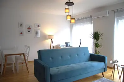 a blue couch in a living room with a table at Yeshill Homes in Budva