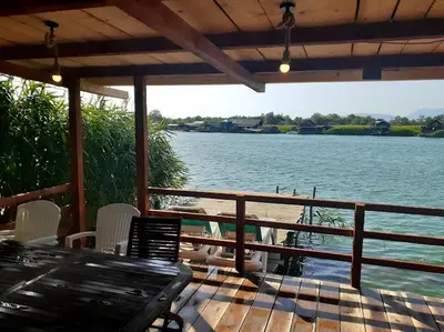a porch with a table and chairs and a body of water at Masa L13 Stasa L14 in Ulcinj