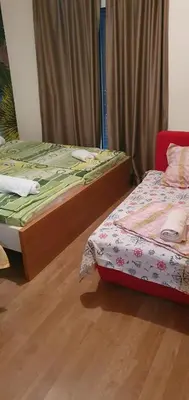 a bedroom with two beds and a wooden floor at Apartmen Kuca za odmor i familiju in Bar