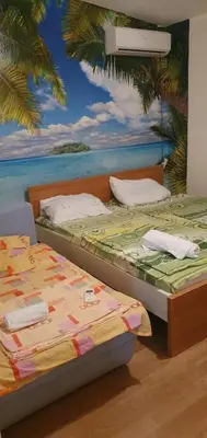 two beds in a room with a mural of the ocean at Apartmen Kuca za odmor i familiju in Bar