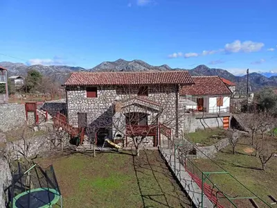 a house with a fence in front of it at Bed & Wine Djonovic in Virpazar