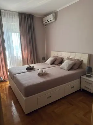a bedroom with a large bed with two stuffed animals on it at Просторная квартира в Петровце с видом на море in Petrovac na Moru