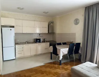 a kitchen and dining room with a table and chairs at Просторная квартира в Петровце с видом на море in Petrovac na Moru