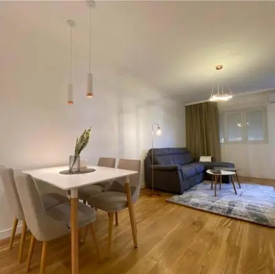 a living room with a table and a blue couch at Apartment in Central Point in Podgorica