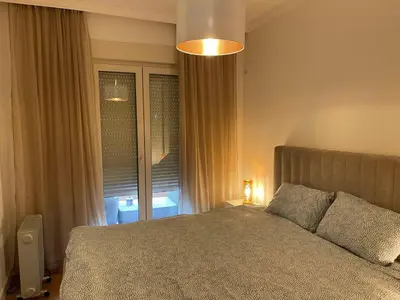 a bedroom with a large bed and a window at Apartment in Central Point in Podgorica
