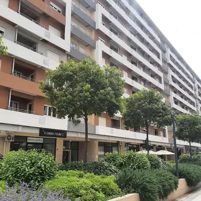 an apartment building with trees in front of it at Apartment in Central Point in Podgorica