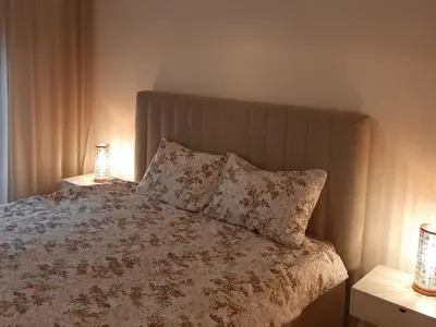 a bed with two lamps and two pillows on it at Apartment in Central Point in Podgorica