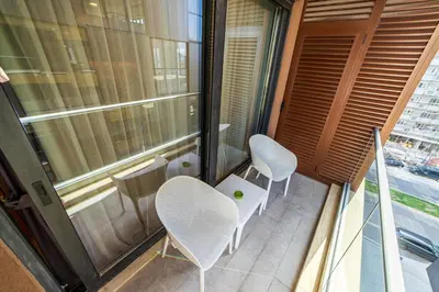 a balcony with two chairs and a table and a window at Elite apartments Podgorica in Podgorica