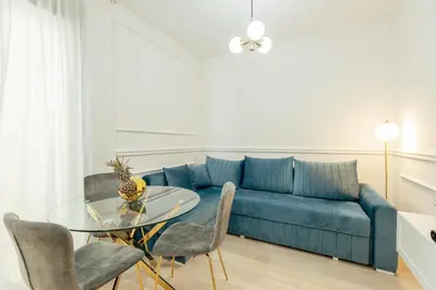 a living room with a blue couch and a glass table at Miracle apartment in Kotor