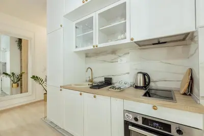 a kitchen with white cabinets and a sink at Miracle apartment in Kotor