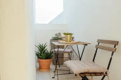 a small table and chairs on a balcony with plants at Miracle apartment in Kotor