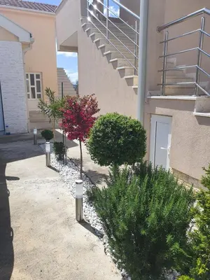 a building with a staircase and plants in a courtyard at Apartman Tološi in Podgorica