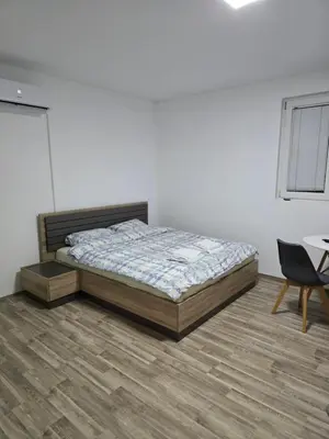 a bedroom with a bed and a table and a chair at Apartman Tološi in Podgorica