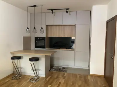 a kitchen with a counter and two bar stools at Stylish charming apartment in Podgorica