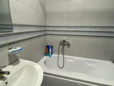 a bathroom with a white tub and a sink at Stylish charming apartment in Podgorica