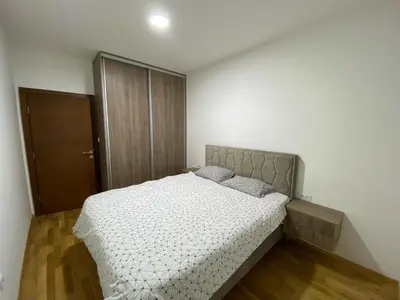 a bedroom with a bed and a brown door at Stylish charming apartment in Podgorica